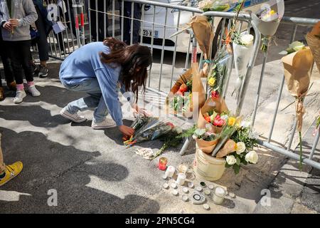 Eine Person legt Blumen zu Ehren der Opfer des Zusammenbruchs. Hundert Menschen haben sich versammelt, um den Opfern des Einsturzes des Gebäudes zu gedenken, das mitten in der Nacht durch eine Explosion explodierte, wahrscheinlich wegen des Gases, das in der Nacht vom 8. Bis 9. April in der Tivoli Straße 17 stattfand, In einem Bezirk vom Zentrum von Marseille. Die Teilnehmer des Gedenkens legten Blumensträuße und Kerzen vor der Sicherheitsbarriere, die den Zugang zum Sicherheitsbereich des Einsturzes blockierte. Acht Menschen, die dort lebten, haben ihr Leben verloren. Stockfoto