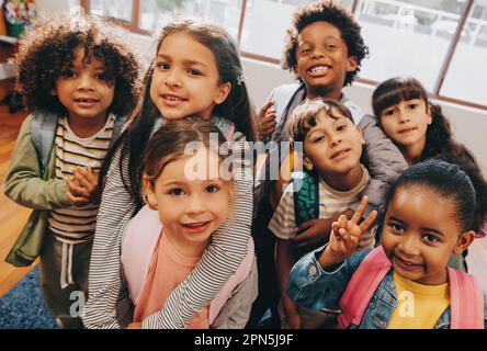 Klassenselfie in einer Grundschule. Kinder, die zusammen ein Foto in einer Studentenschule machen. Eine Gruppe von Grundschulkindern, die sich freuen, wieder hier zu sein Stockfoto