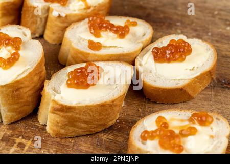 Zartes französisches Baguette aus Weizenmehl, frisches Baguette mit Butter und rotem Lachskaviar Stockfoto