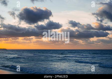Hintergrundbild von farbenfrohem Himmel und wunderschöner Wasserreflexion. wolkiger violetter Himmel und Meer im Abendlicht Stockfoto