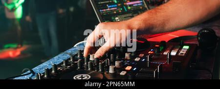 Hände eines DJs in einer Kabine, die auf dem Mixer im Club spielt Stockfoto