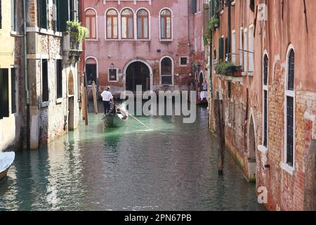 VENEDIG, ITALIEN - 10. SEPTEMBER 2018: Nicht identifizierte Personen fahren mit einer Gondel entlang der alten Kanäle im Innern der Stadt. Stockfoto