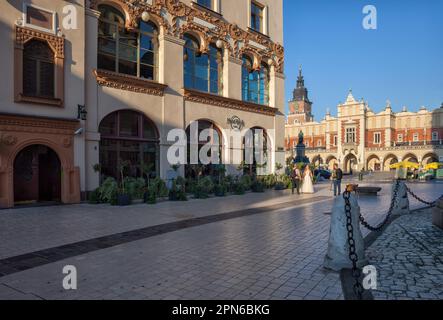 Stadt Krakau in Polen, Hard Rock Cafe und Tuchhalle am Hauptmarktplatz in der Altstadt, vom Mariacki Platz am Morgen aus gesehen. Stockfoto