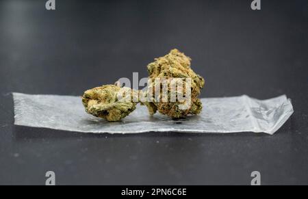 Berlin, Deutschland. 15. April 2023. Eine Cannabisblume liegt auf einer Plastiktüte. Kredit: Hannes P. Albert/dpa/Alamy Live News Stockfoto