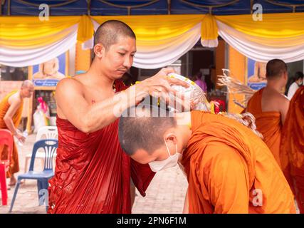 Ban Chang, Thailand - 16. April 2023: Mönche gießen Wasser mit Blütenblättern über einander, um Songkran, das buddhistische Neujahr, im Wat Chak Mak zu feiern Stockfoto