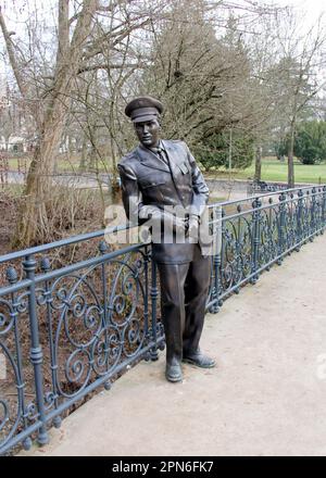 Bronzestatue von Elvis Presley, in US-Armeeuniform, auf der Fußgängerbrücke über den Fluss USA im Kurpark, Bad Nauheim, Deutschland Stockfoto