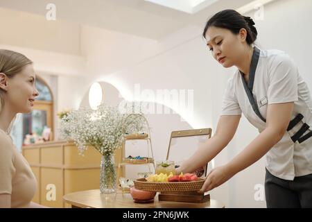 Schönheitssalon an der Rezeption, der Gästen frisches Obst und Eistee bringt Stockfoto