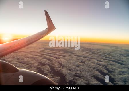 Blick aus dem Flugzeug über die Wolken in Madrid, Spanien bei Sonnenuntergang Stockfoto