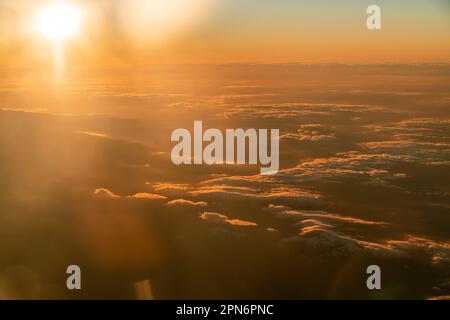 Blick aus dem Flugzeug über die Wolken in Madrid, Spanien bei Sonnenuntergang Stockfoto