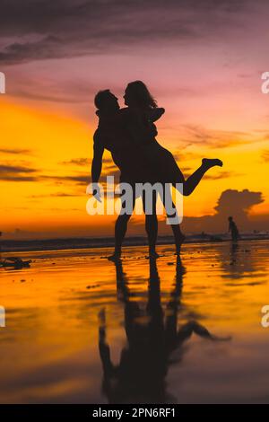 Ein Paar, das Spaß am Strand hat. Sonnenuntergang auf Bali. Stockfoto