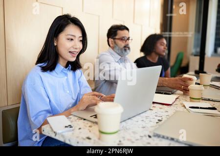 Geschäftsfrau, die Videoanrufe auf dem Laptop macht, während sie im Café sitzt Stockfoto