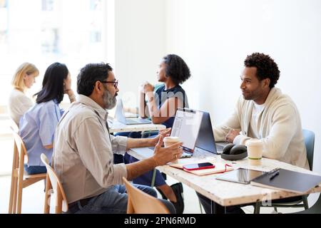Männliche Unternehmer diskutieren während des Meetings im Café Stockfoto