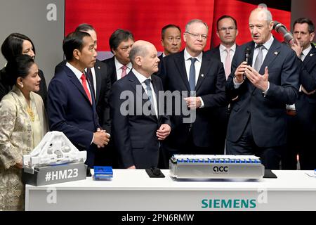 Hannover, Deutschland. 17. April 2023. Roland Busch (r), CEO der Siemens AG, erläutert dem deutschen Bundeskanzler Olaf Scholz (SPD M), Joko Widodo (3. von links), Präsident Indonesiens, seiner Frau Iriana (l) und Stephan weil (SPD, 4. von rechts), einen weißen Halter aus dem 3D-Drucker für einen Roboter, der in der Batterieproduktion verwendet wird. Ministerpräsident Niedersachsens, während der Eröffnungstour der Hannover Messe am Stand Siemens. Die weltweit größte Industriemesse findet vom 17. Bis 21. April statt. Kredit: Julian Stratenschulte/dpa/Alamy Live News Stockfoto