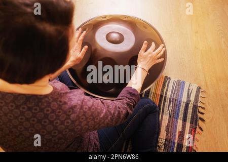 Rückansicht, Hände an einem ungewöhnlichen Musikinstrument Stockfoto