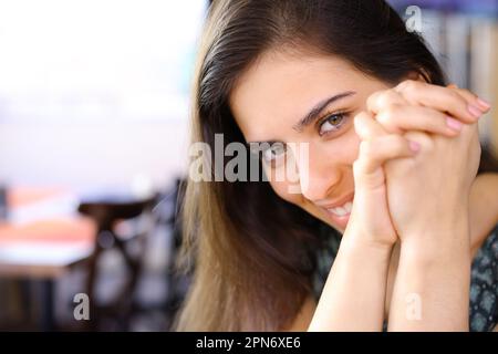 Eine schüchterne Frau, die dich in einem Restaurant ansieht Stockfoto