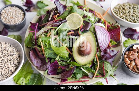 Salat mit Avocado und Gemüse gemischte grüne Salatblätter, fertig zum Essen. Stockfoto