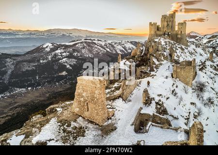 Luftaufnahme der Rocca di Calascio mit Schnee und Beleuchtung im Licht des Sonnenuntergangs. Gran Sasso und Monti della Laga National Park, Abruzzen Stockfoto