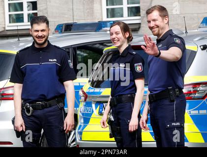 Bochum, Deutschland. 17. April 2023. Eine Polizistin und zwei ihrer Kollegen demonstrieren die drei neuen Polohemden vor dem Polizeipräsidium. Erste Polizeibeamte in Nordrhein-Westfalen testen Polohemden, 50 Beamte aus Bochum testen die Modelle von drei Herstellern vier Wochen lang. Kredit: Roland Weihrauch/dpa/Alamy Live News Stockfoto