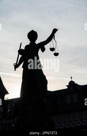 Denkmal der Justizfrau mit Hintergrundbeleuchtung und blauem Himmel im Hintergrund Stockfoto