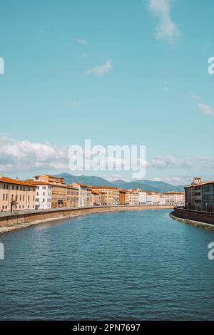 Wunderschöner Blick auf die Gebäude am Fluss Arno in Pisa, Italien. Eine Brücke führt über den Fluss und Häuser auf beiden Seiten blicken auf das Wasser. Hallo Stockfoto