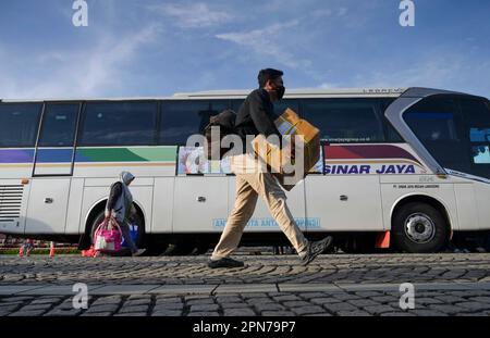 Jakarta, Indonesien. 17. April 2023. Personen nehmen am 17. April 2023 ihre persönlichen Gegenstände mit, um an Bord kostenloser Busse zu ihren Heimatorten in Jakarta, Indonesien, zu gehen. Indonesien steht vor der Heimkehr-Saison, in der Menschen aus städtischen Städten in ihre jeweiligen Heimatorte zurückkehren, um Eid mit ihren Familien zu feiern. Kredit: Zulkarnain/Xinhua/Alamy Live News Stockfoto