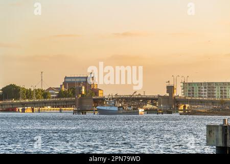 Industriegebiet von Port Adelaide mit einem Fischboot und der Birkenhead Bridge über den Port River bei Sonnenuntergang, Südaustralien Stockfoto
