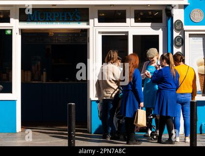 Mitarbeiter von Murphy's bieten Studenten an der Main Street in Killarney, County Kerry, Irland, kostenlose Eiscremeproben an Stockfoto