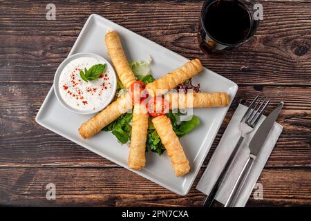 Türkische Zigarrenrollen auf einer weißen Porzellanplatte. Der türkische Name ist Sigara Boregi Stockfoto