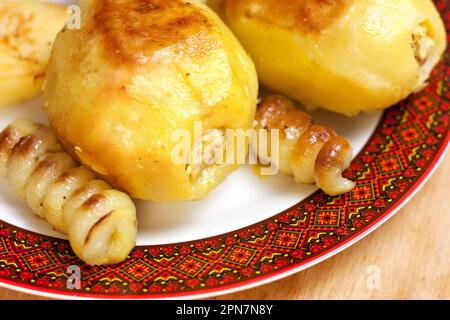 Leckere ganze Kartoffeln gefüllt mit Hackfleisch auf einem Teller mit rotem Rand Stockfoto