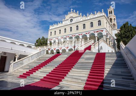 Panagia von Tinos Island, Kykladen, Griechenland. Griechisch-orthodoxe Kirche, Marmortempel, roter Teppich auf der Treppe, blauer Himmelshintergrund. Stockfoto