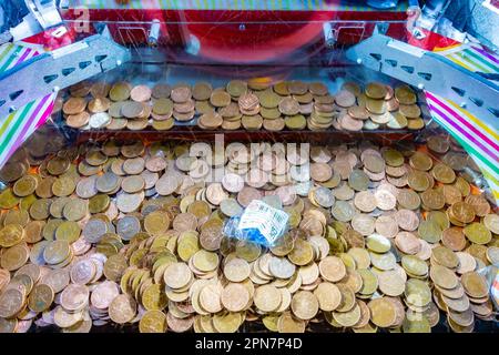Nahaufnahme von zwei Pence-Münzen in einer Penny Fall-Maschine in einer Vergnügungskunstkarte Stockfoto