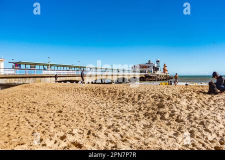 Der Bournemouth Pier in Dorset, Großbritannien, wurde im April gesehen, so dass der Strand relativ ruhig unter einem klaren, blauen Himmel ist Stockfoto