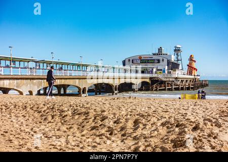 Der Bournemouth Pier in Dorset, Großbritannien, wurde im April gesehen, so dass der Strand relativ ruhig unter einem klaren, blauen Himmel ist Stockfoto