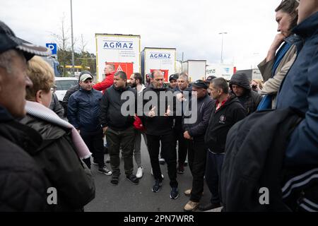 PRODUKTION – 17. April 2023, Hessen, Weiterstadt: LKW-Fahrer sprechen mit Gabriele Bischoff (SPD, l), Mitglied des Europäischen Parlaments, und Agnes Jongerius (Partij van de Arbeid, r), Mitglied des Europäischen Parlaments, während eines Streiks von LKW-Fahrern eines polnischen Logistikunternehmens im Servicegebiet Gräfenhausen West. Die Lkw-Fahrer fordern seit mehreren Wochen ausstehende Löhne von ihrem Arbeitgeber. Foto: Sebastian Gollnow/dpa Stockfoto