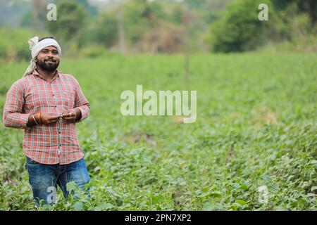 Glücklicher indischer Bauer, junger Bauer lächelt auf der Farm Stockfoto