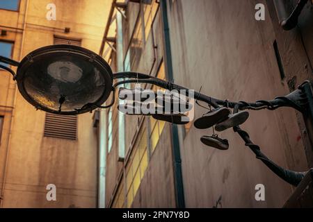 Alte Schuhe, die an einer Lichterstange hängen Stockfoto