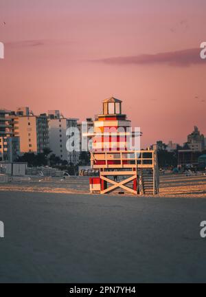 Ein heller Rettungsschwimmturm steht fest im Sand an einem wunderschönen Strand Stockfoto