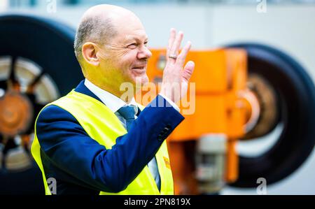 Hannover, Deutschland. 17. April 2023. Bundeskanzler Olaf Scholz (SPD) winkt seinen Mitarbeitern bei seinem Besuch des Werks Continental zum Thema Runderneuerung von Lkw- und Busreifen zu. Kredit: Moritz Frankenberg/dpa/Alamy Live News Stockfoto