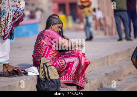 Varanasi, Indien - Nov. 2022: Porträt einer indianerin, die in der Nähe von ganges Ghat in traditionellem Saree sitzt. Selektiver Fokus auf Augen und Gesicht. Stockfoto