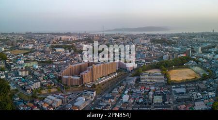 Luftaufnahme der Akashi City Gebäude und Brücke zur Awaji Insel bei Sonnenuntergang Stockfoto