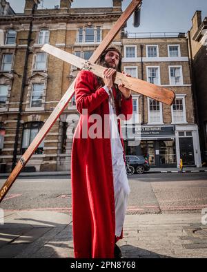 Ein schauspielender Jesus Christus trägt das Kreuz auf den Straßen Londons am Ostersonntag. Stockfoto