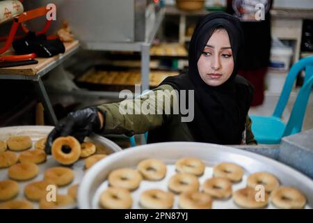 Gaza, Palästina. 17. April 2023. Palästinensische Frauen bereiten traditionelle Dattelkekse zu, die sie vor dem bevorstehenden Eid al-Fitr, dem Ende des muslimischen Fastenmonats Ramadan, am 17. April 2023 in Gaza-Stadt, an benachteiligte Familien verteilen. Foto: Ramez Habboub/ABACAPRESS.COM Kredit: Abaca Press/Alamy Live News Stockfoto