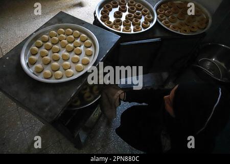 Gaza, Palästina. 17. April 2023. Palästinensische Frauen bereiten traditionelle Dattelkekse zu, die sie vor dem bevorstehenden Eid al-Fitr, dem Ende des muslimischen Fastenmonats Ramadan, am 17. April 2023 in Gaza-Stadt, an benachteiligte Familien verteilen. Foto: Ramez Habboub/ABACAPRESS.COM Kredit: Abaca Press/Alamy Live News Stockfoto