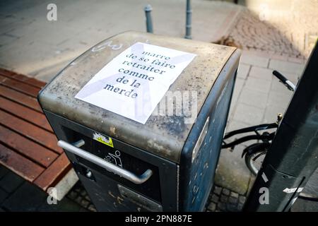 Straßburg, Frankreich - 20. März 2023: Aufkleber auf dem Müllcontainer, den Demonstranten hinterlassen haben, stellt eine Rentenreform in Straßburg in Frankreich in Frage Stockfoto