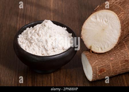 Rohe Kassava-Wurzel Und Stärke – Maniok-Esculenta; Auf Holzhintergrund Stockfoto