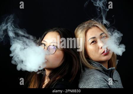 Profilsilhouette einer rauchenden Frau auf weißem Hintergrund. Stockfoto