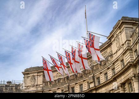 LONDON - 18. Mai 2022: Die Flaggen des Weißen Fähnrich fliegen stolz vom Admiralty Arch in London und verleihen der Feier des Pla einen patriotischen Touch Stockfoto