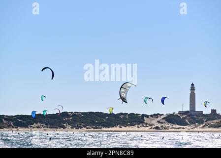 Los Caños de Meca, Barbate, Cádiz; 19. August 2022: Athleten, die Kitesurfen vor dem Strand des Leuchtturms Trafalgar üben Stockfoto