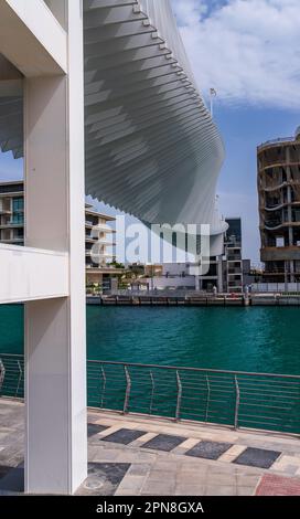 Spiraldesign der Dubai Water Canal Bridge über den Wasserweg zu Apartmentblöcken Stockfoto