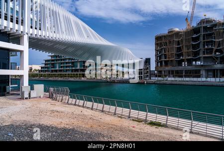 Spiraldesign der Dubai Water Canal Bridge über den Wasserweg zu Apartmentblöcken Stockfoto